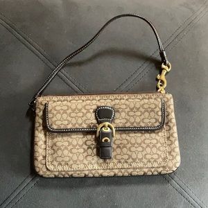 Brown Coach clutch purse with leather strap.